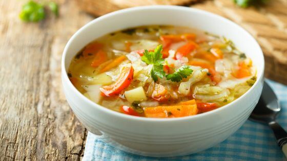 Chicken and vegetable soup in white bowl