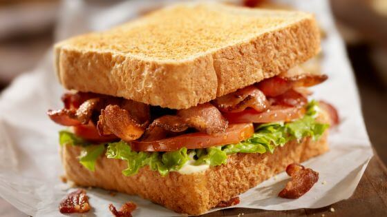 Bacon, lettuce and tomato sandwich on a white paper