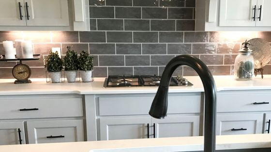 kitchen counters and white kitchen cabinets and black faucet