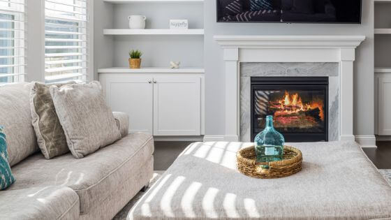 White living room with fireplace and ottoman