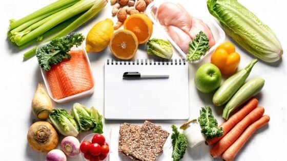 Food on a table with a notebook and pen