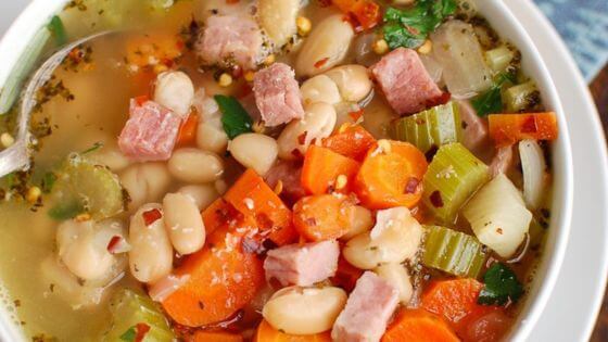 Ham and bean soup in white bowl