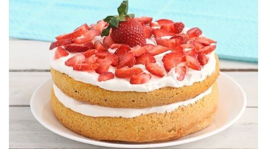 cake with white cream frosting and strawberries
