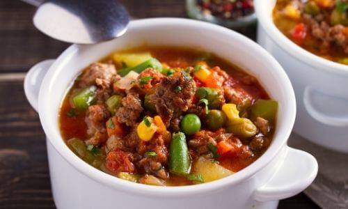 hamburger soup with vegetables in white bowl