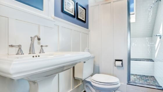 bathroom sink and toilet with blue and white walls