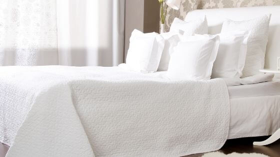 bed with white pillows and bedspread