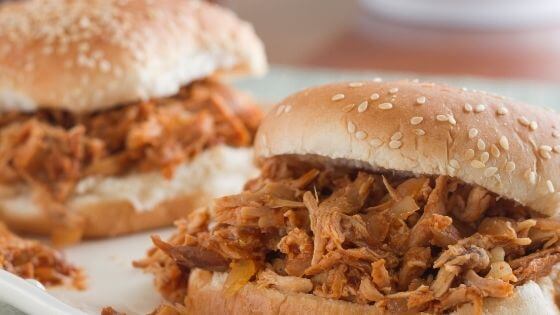 Shredded barbecue chicken sandwich on sesame roll