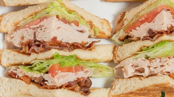 Turkey club with turkey, bacon, lettuce, tomato on bread