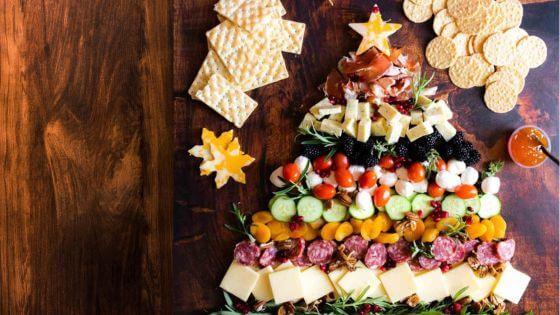 Christmas tree charcuterie board with cheese, tomatoes, meat and vegetables