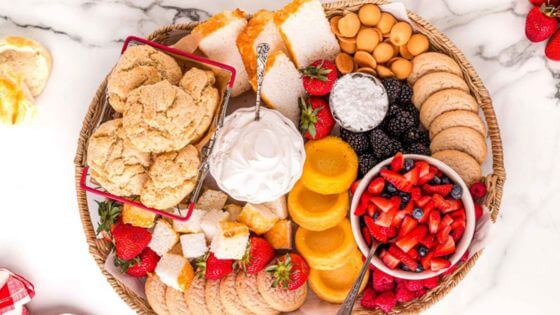 Charcuterie board with shortcake, strawberries, angel food cake and cream.