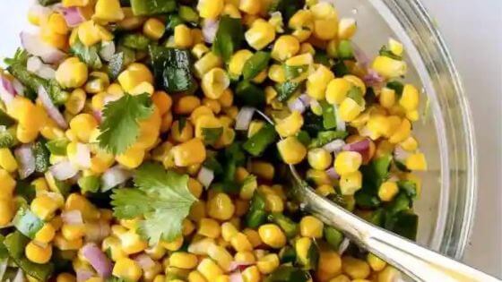 corn salsa in glass dish with spoon