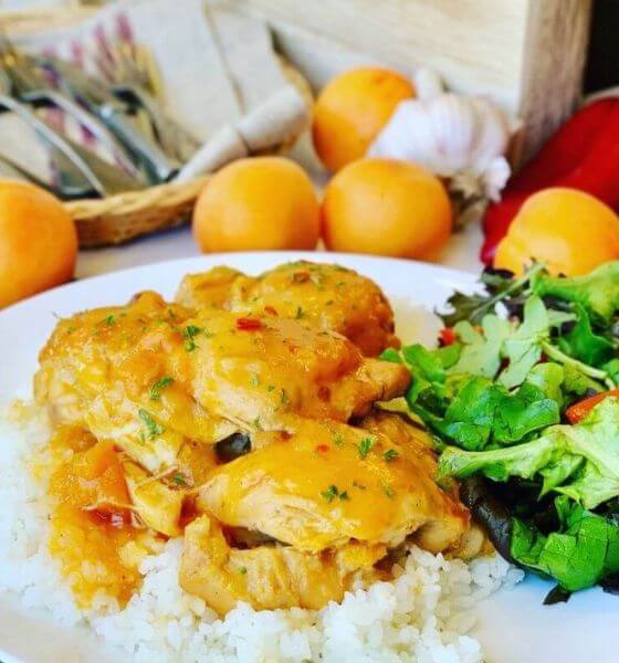 Slow cooker apricot chicken on white plate with rice and broccoli