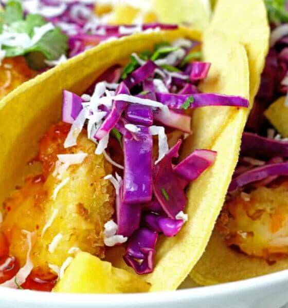 Coconut Shrimp with slaw on tortilla shell on white plate