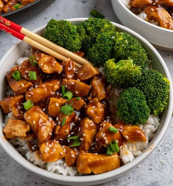 Honey Teriyaki Chicken with a side of broccoli on white plate with chopsticks