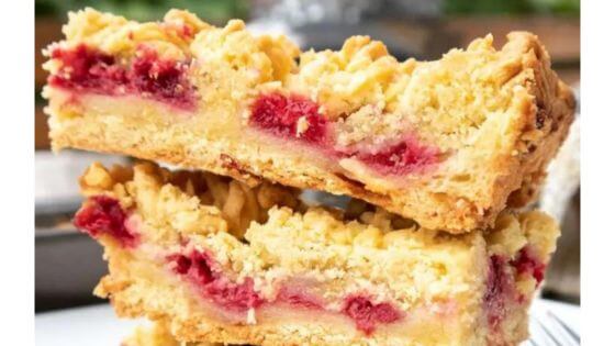 Raspberry bars stacked on a white plate