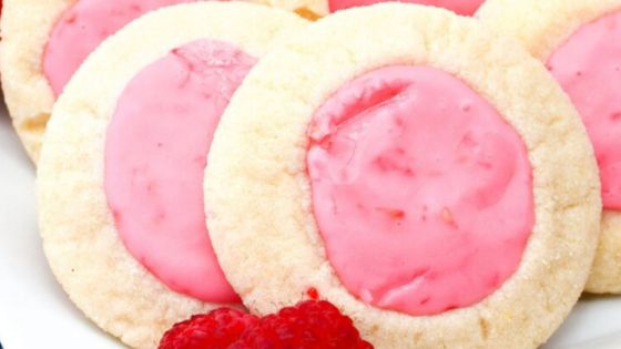 Raspberry thumbprint cookie on a white surface
