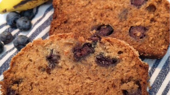 Blueberry banana bread with crumb topping on blue and white towel
