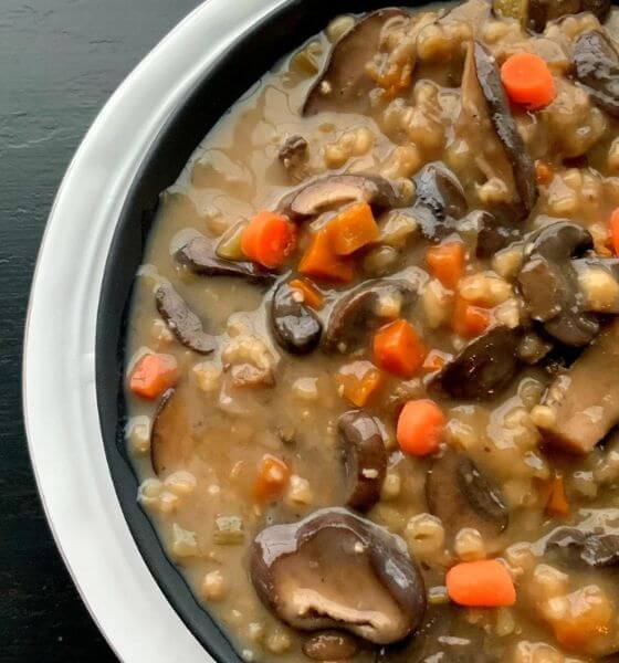 Slow cooker mushroom and barley soup in white and navy blue bowl