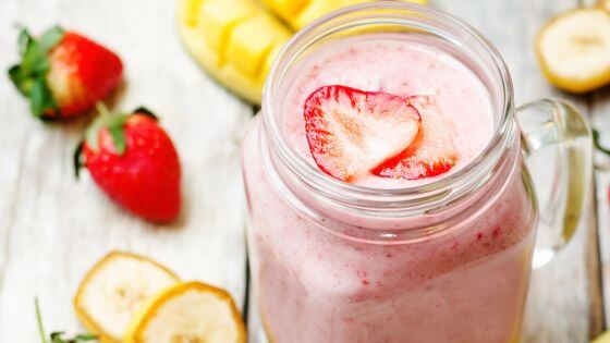 Strawberry banana smoothie in mason glass jar to grab and go