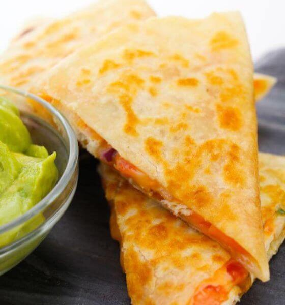 Chicken quesadillas stacked on a black plate
