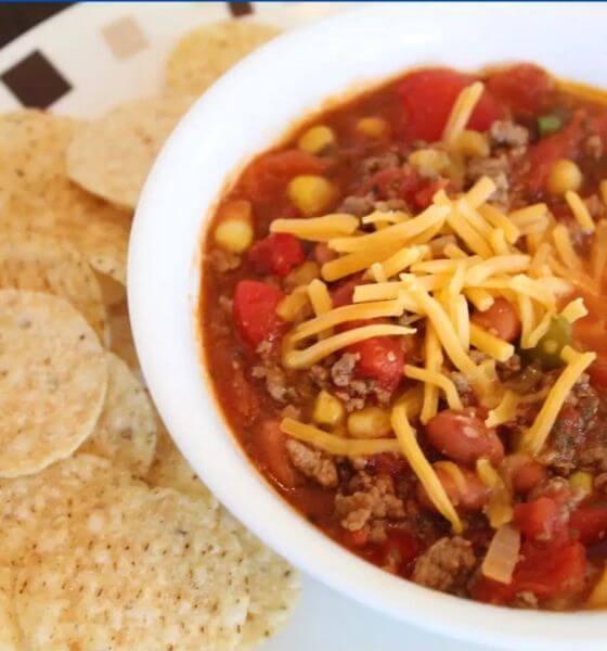 Chili in white bowl with shredded cheese on top