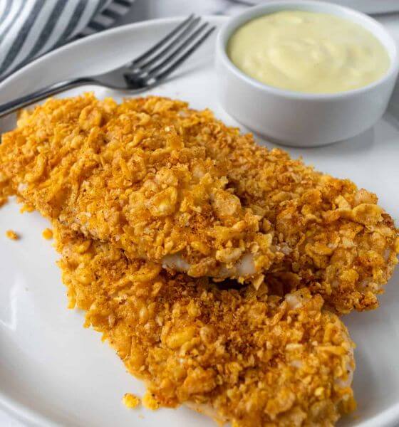 Cornflake breaded chicken tenders on white plate