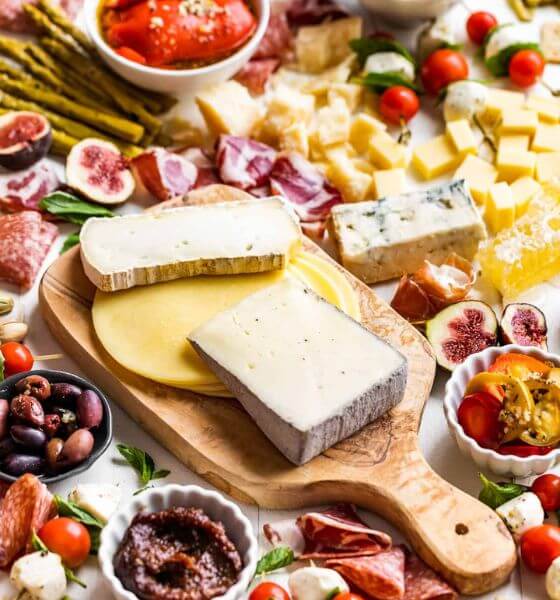 Antipasto platter with different types of cheese, olives and tomatoes.