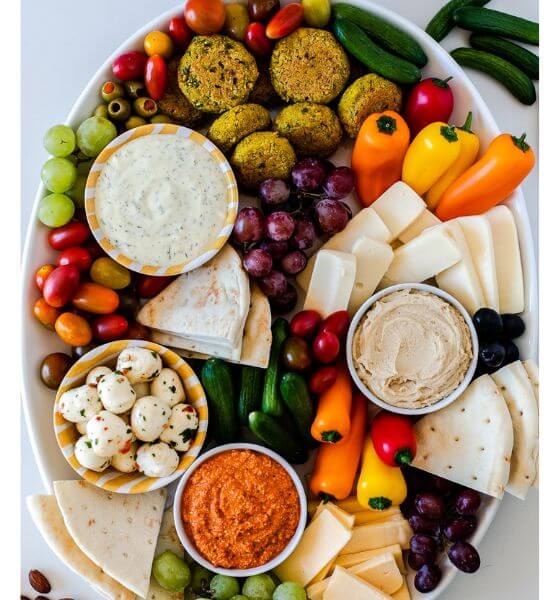 Mezzo board with tortillas, peppers, tomatoes, grapes and cheese.