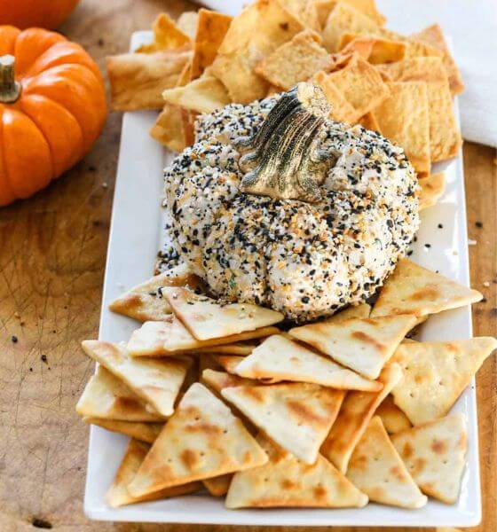 Pumpkin shaped cheeseball with crackers on the side