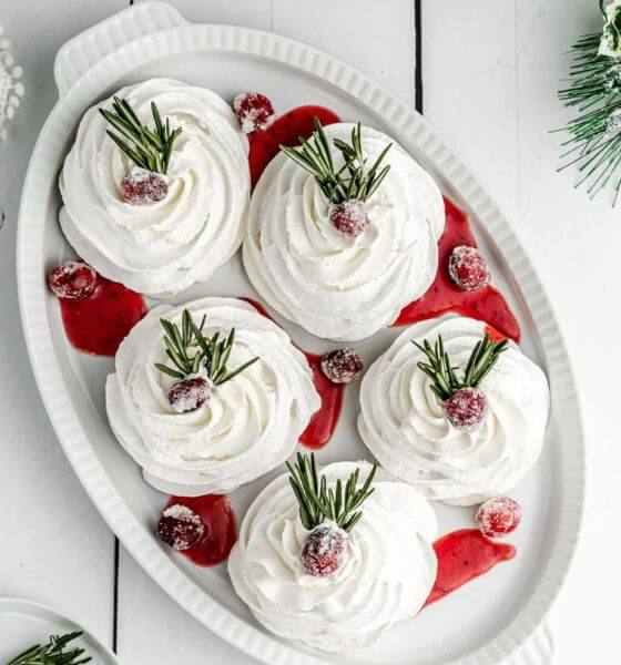 Christmas pavlova on a white platter with cranberries