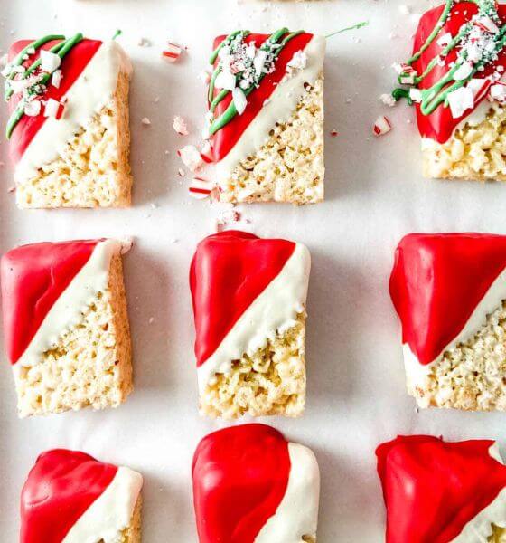 Christmas Rice Krispy Treats that have been dipped in red and white icing with crushed peppermint candies on top