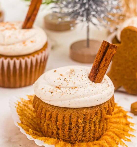 Gingerbread cups with vanilla frosting and a cinnamon stick on the top.