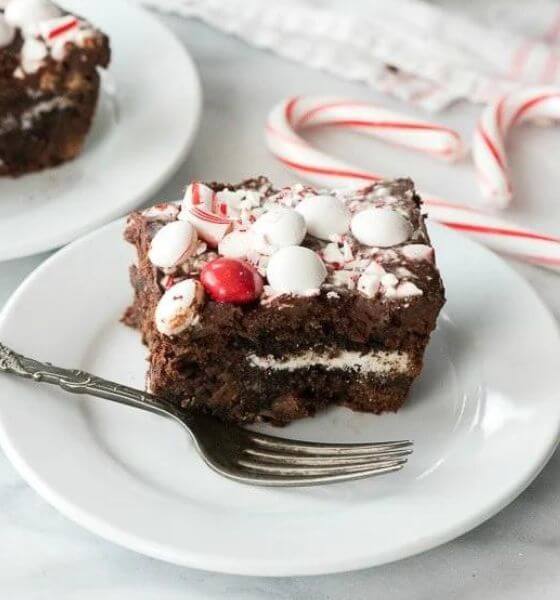 Peppermint brownies with crushed candy canes on a white plate with fork