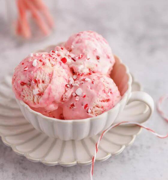 Candy cane ice cream in white cup on a white saucer