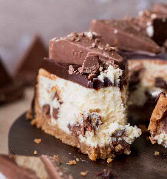 A slice of toblerone cheesecake on dark wood board