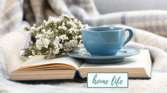 Blue coffee cup on opened book with flowers
