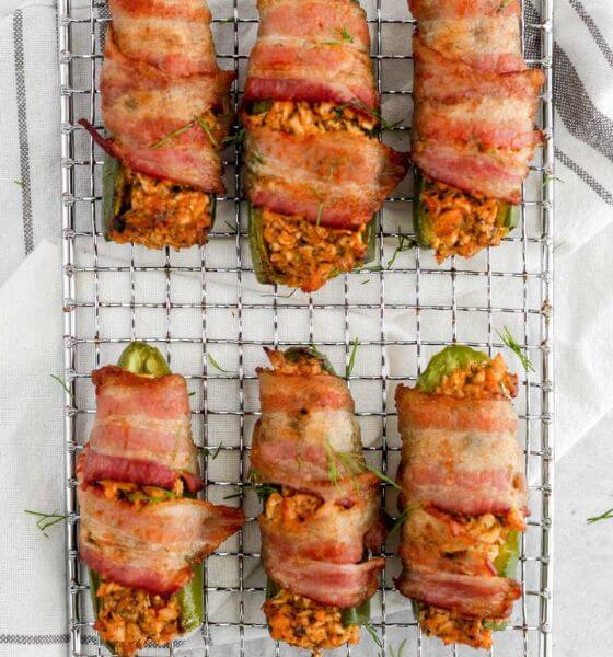 Buffalo chicken poppers wrapped in bacon on metal grate