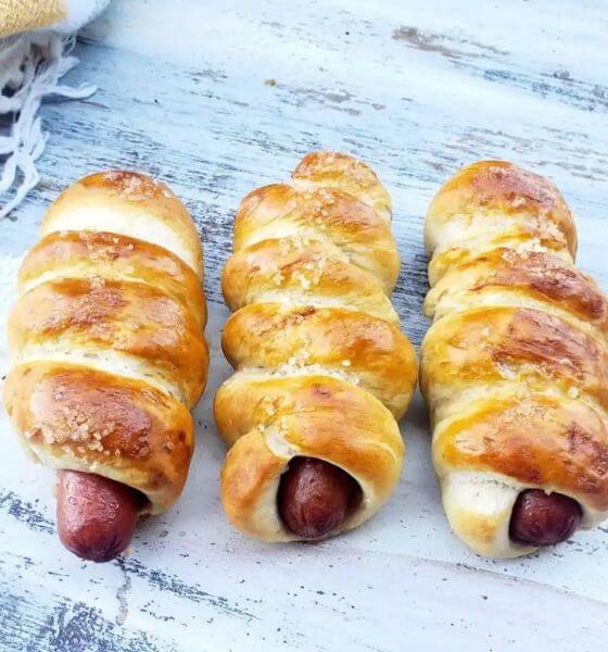 Pretzel dogs on a white wood background