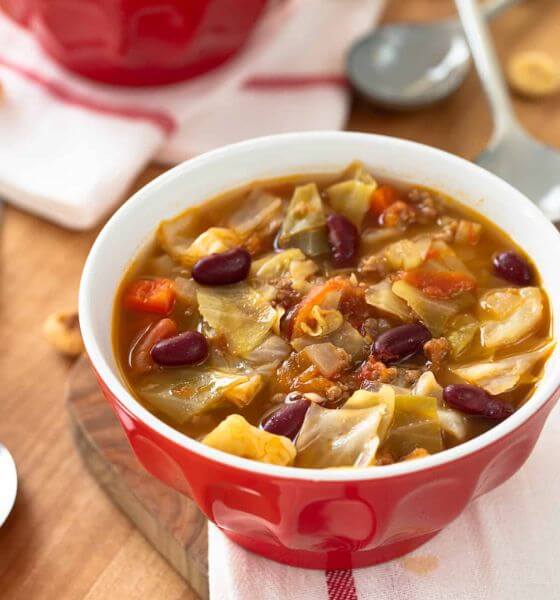 Beef cabbage soup in red and white bowl