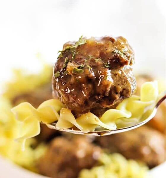 meatballs and gravy with egg noodles on spoon