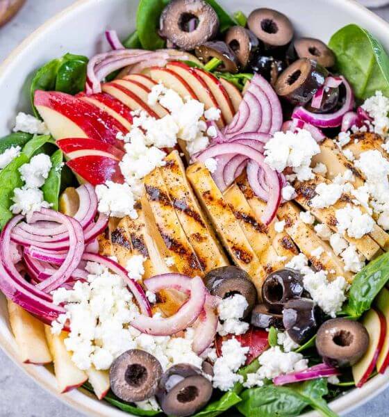 Grilled chicken apple feta chicken salad with olives and onions in white bowl