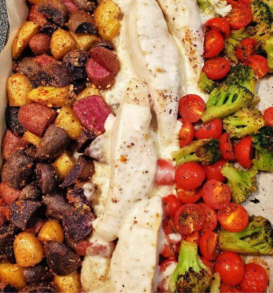Chicken with mozzarella, potatoes and vegetables on a baking sheet
