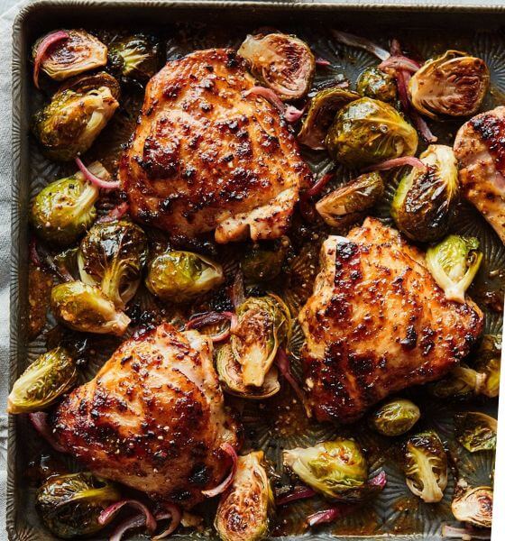 Honey mustard chicken and brussels sprouts on a baking sheet