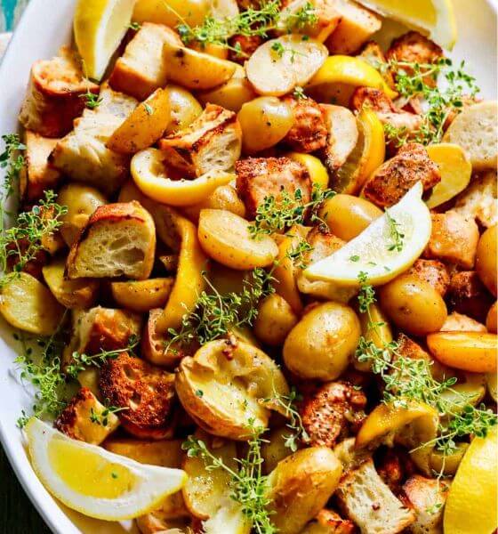 Chicken and vegetables cooked on a sheet pan in a white serving dish
