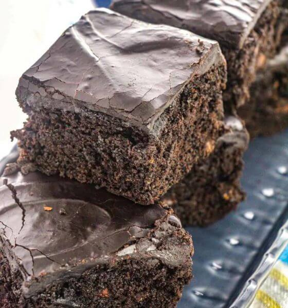 Zucchini brownies cut into squares with frosting