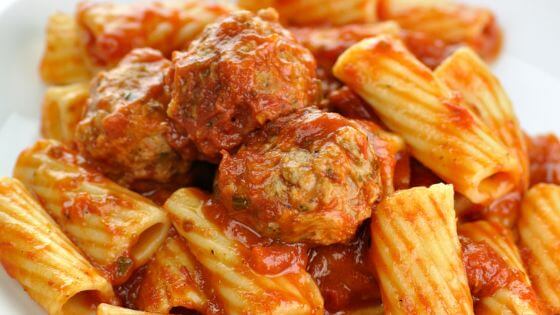 rigatoni and meatballs on white plate