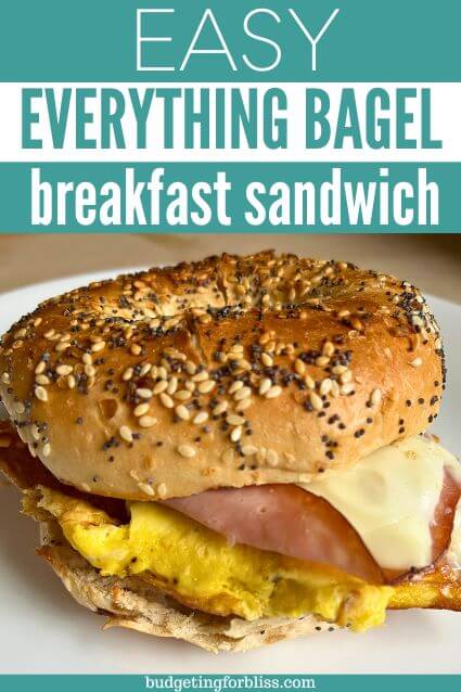 Cheesy bagel sandwich on plate with eggs, cheese and ham