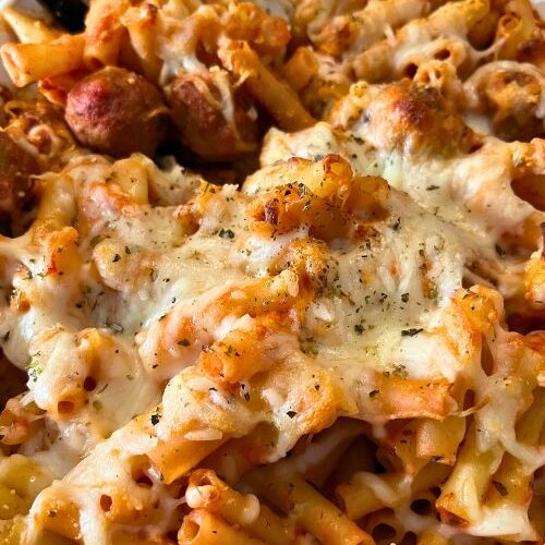 Baked Ziti with meatballs in white casserole dish