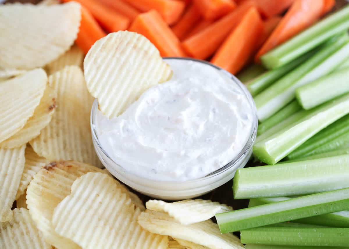 homemade French onion dip on platter with chips, and veggies