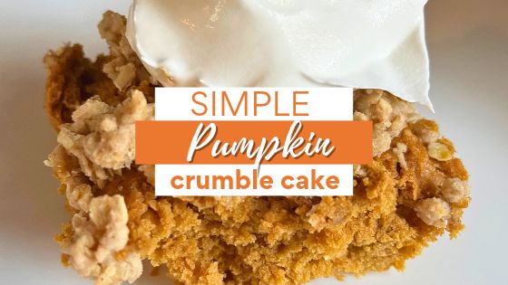 Pumpkin crumble cake on white plate with whipped topping